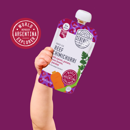 Hand holding a Serenity Kids beef chimichurri pouch against a purple background with 'World Inspired by Argentina Explorer' branding.