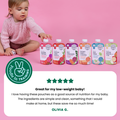 Baby sitting next to world explorer baby food pouches with a 5 star customer review on a pink background