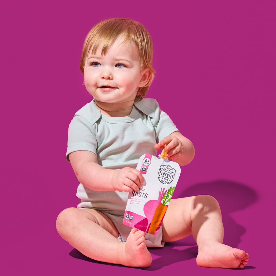 Child holding a package of organic roots against a purple background