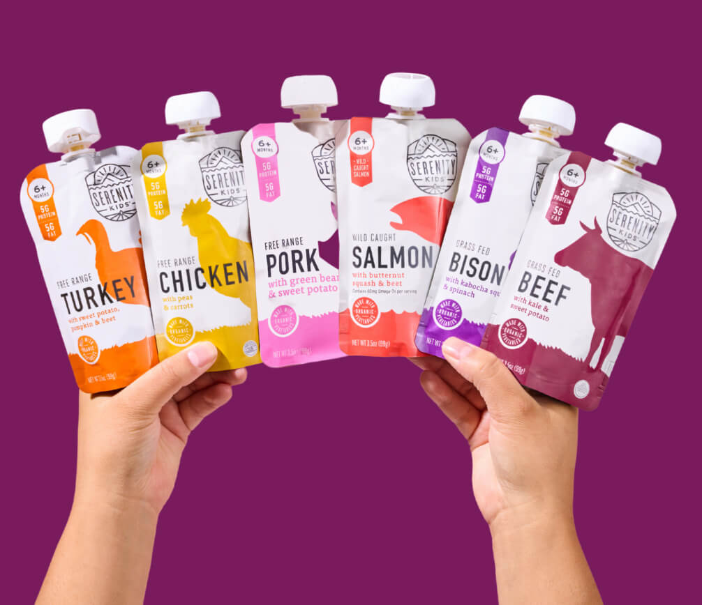 Hands holding Serenity Kids meat pouches in different flavors