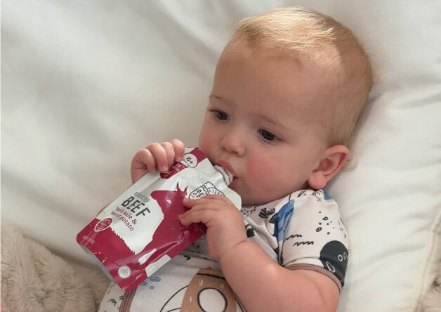 Baby eating from a Serenity Kids pouch